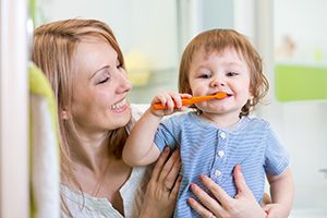 Mother Holding Son Brushing Teeth