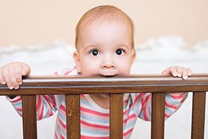 Baby Boy Chewing on Crib